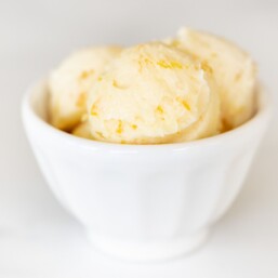 A white bowl filled with scoops of homemade orange butter.