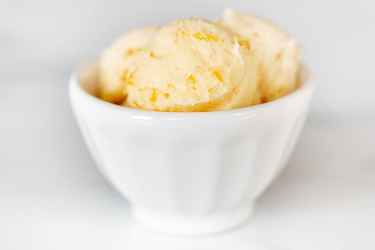 A white bowl filled with scoops of homemade whipped orange butter.