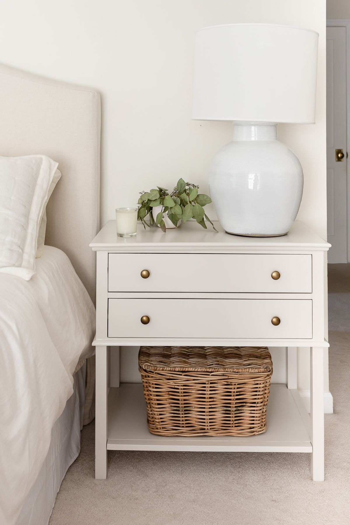 A nightstand in a cream bedroom, painted in Benjamin Moore Pale Oak paint color.