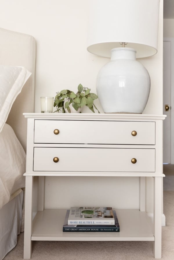 A nightstand in a cream bedroom, painted in Pale Oak Benjamin Moore paint color.