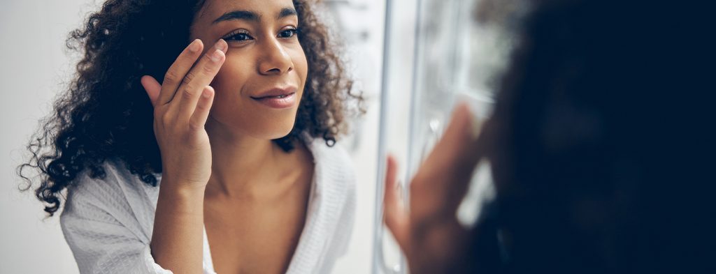 Woman examining face in mirror