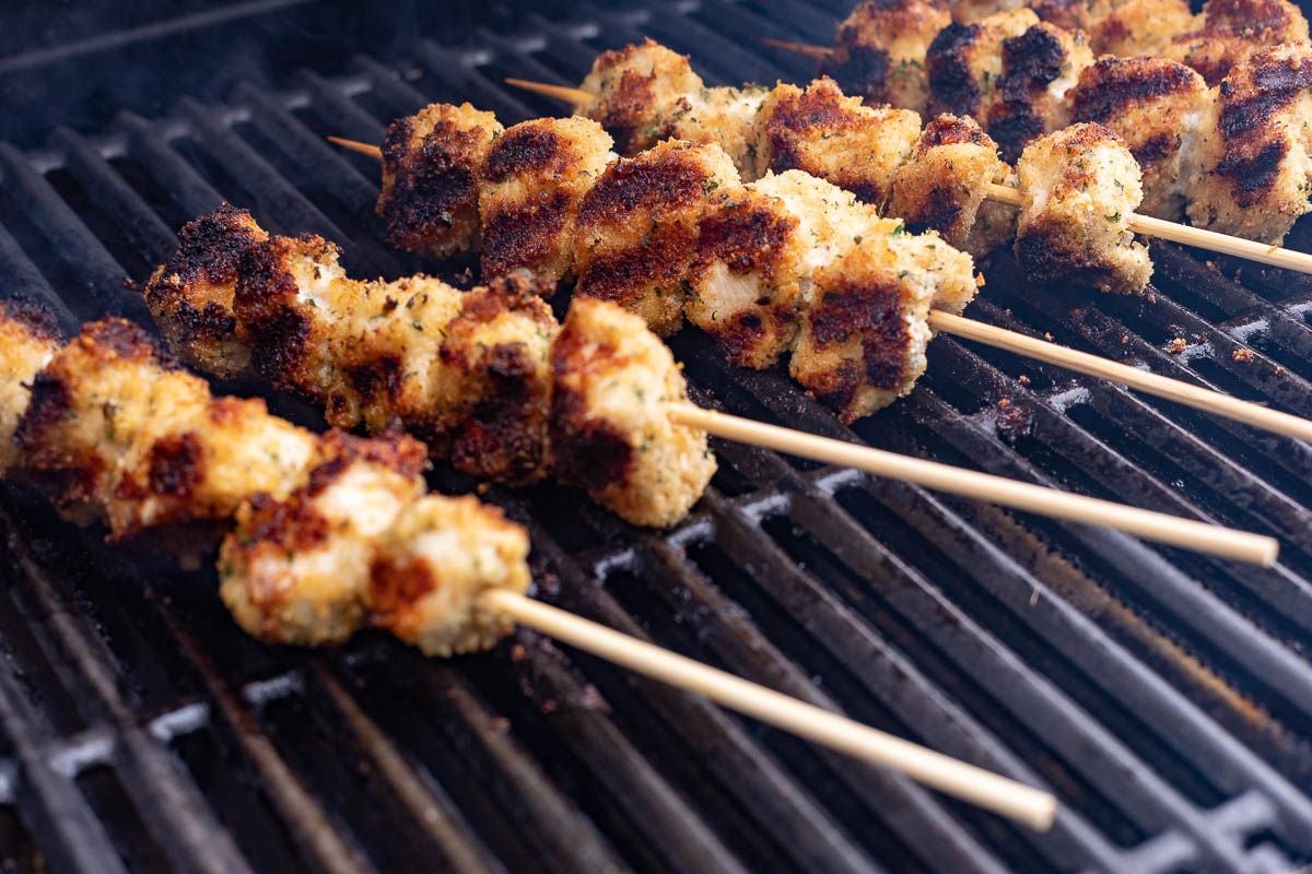 Spiedini skewers cooking on a grill.