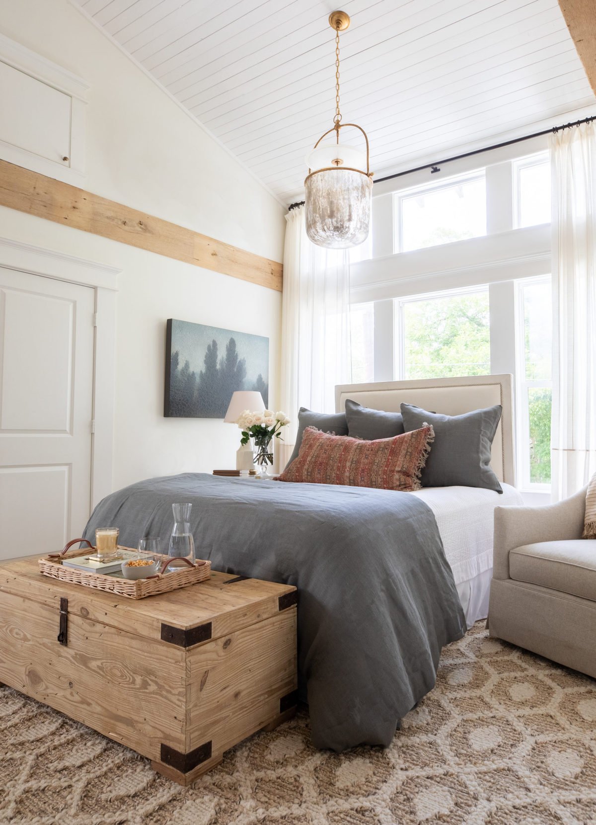 A guest room with Cloud White painted walls and wood beams