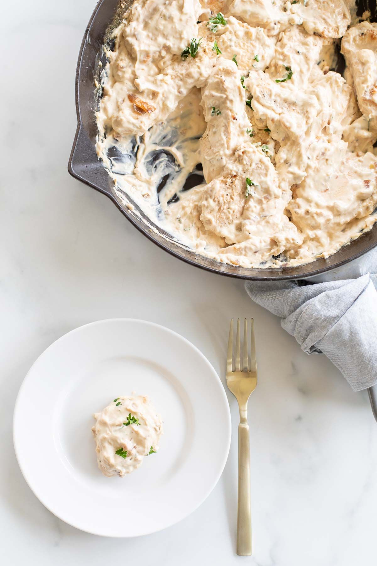 A cast iron skillet filled with cream cheese chicken