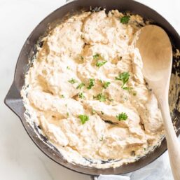 A cast iron skillet filled with cream cheese chicken
