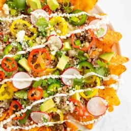 A plate full of a Doritos nachos recipe on a white surface.