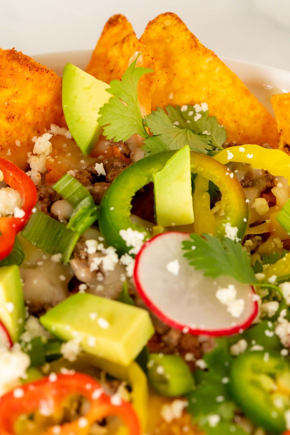 A close up of a Doritos nachos recipe loaded with toppings.