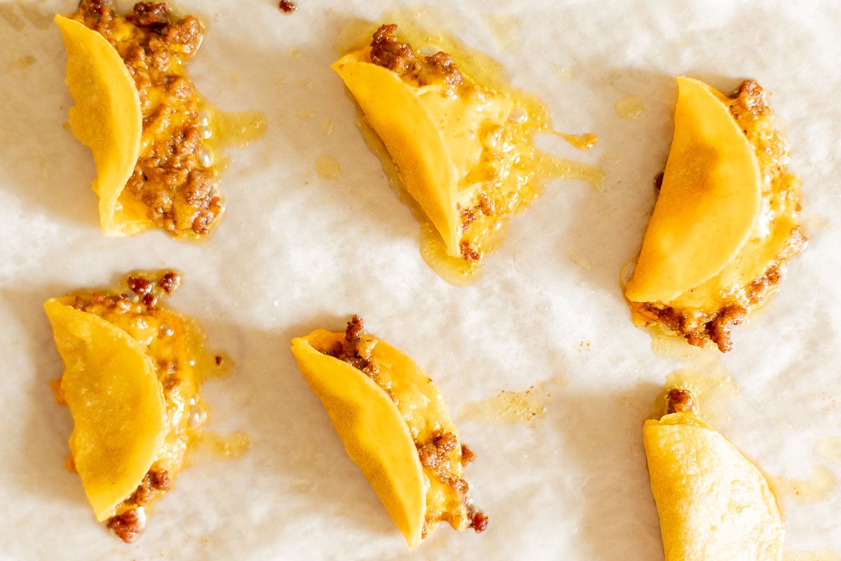 mini tacos on a parchment lined baking sheet.