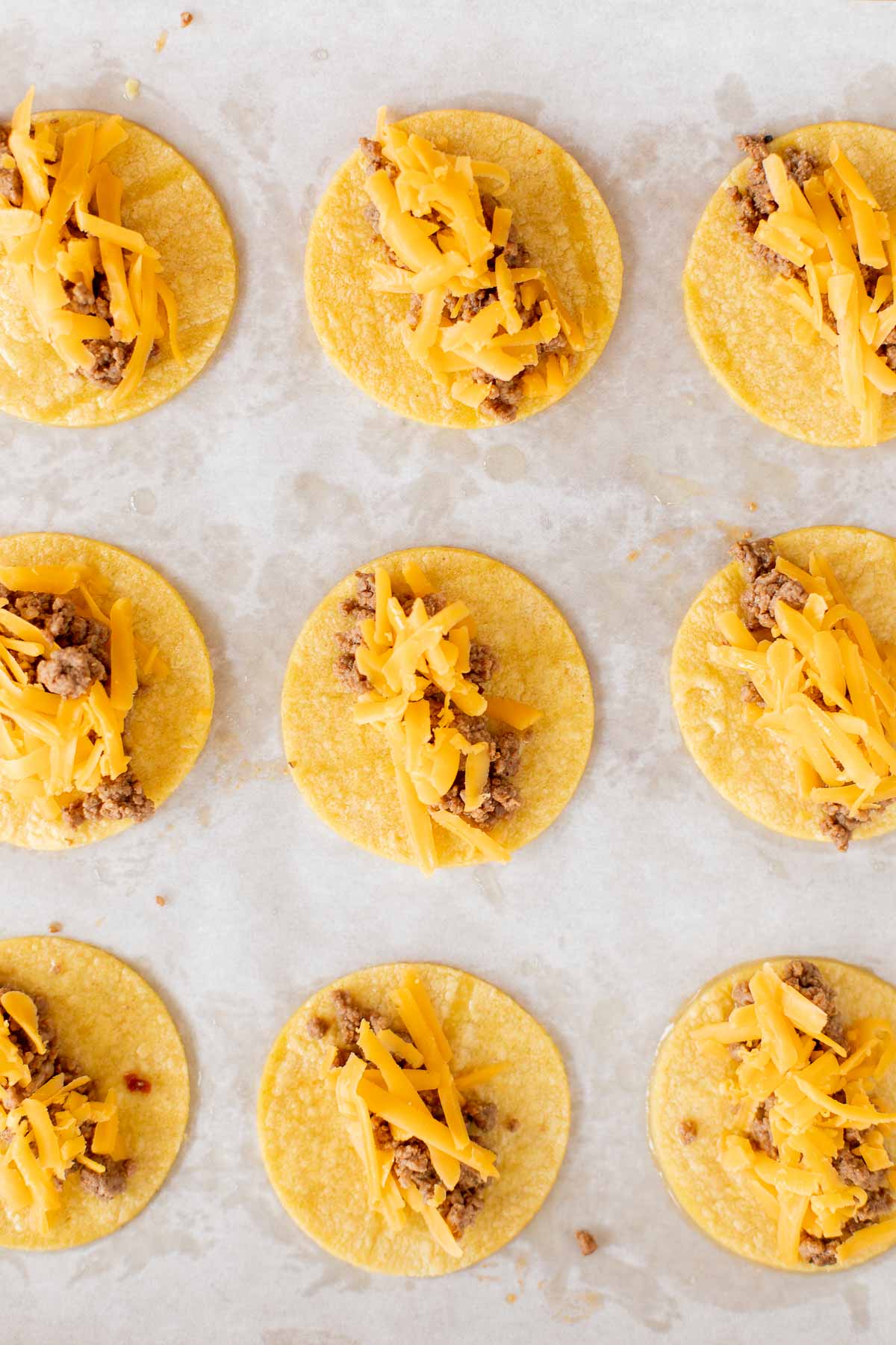 mini tacos on a parchment lined baking sheet.