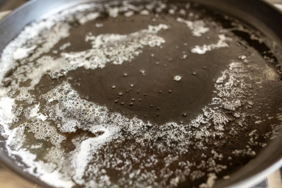 A cast iron skillet with melted bubbling butter