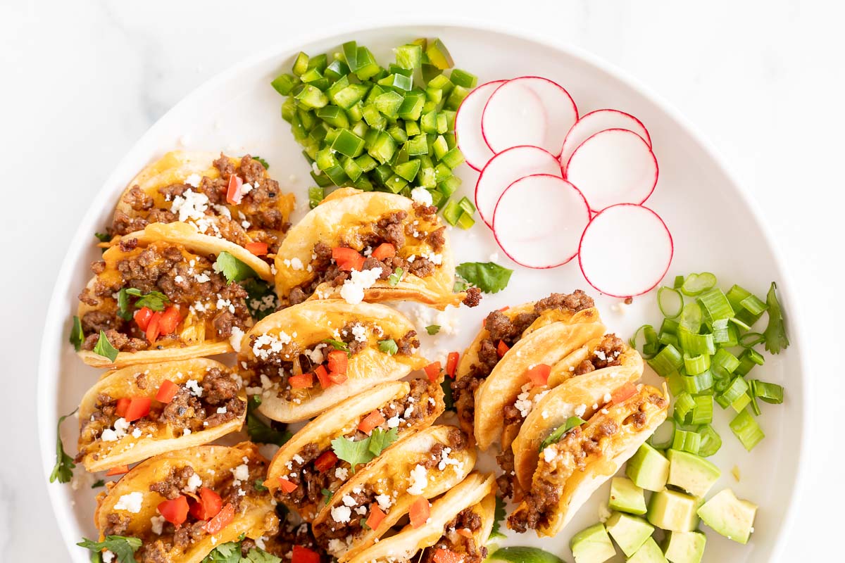 Beef mini tacos on a white platter.