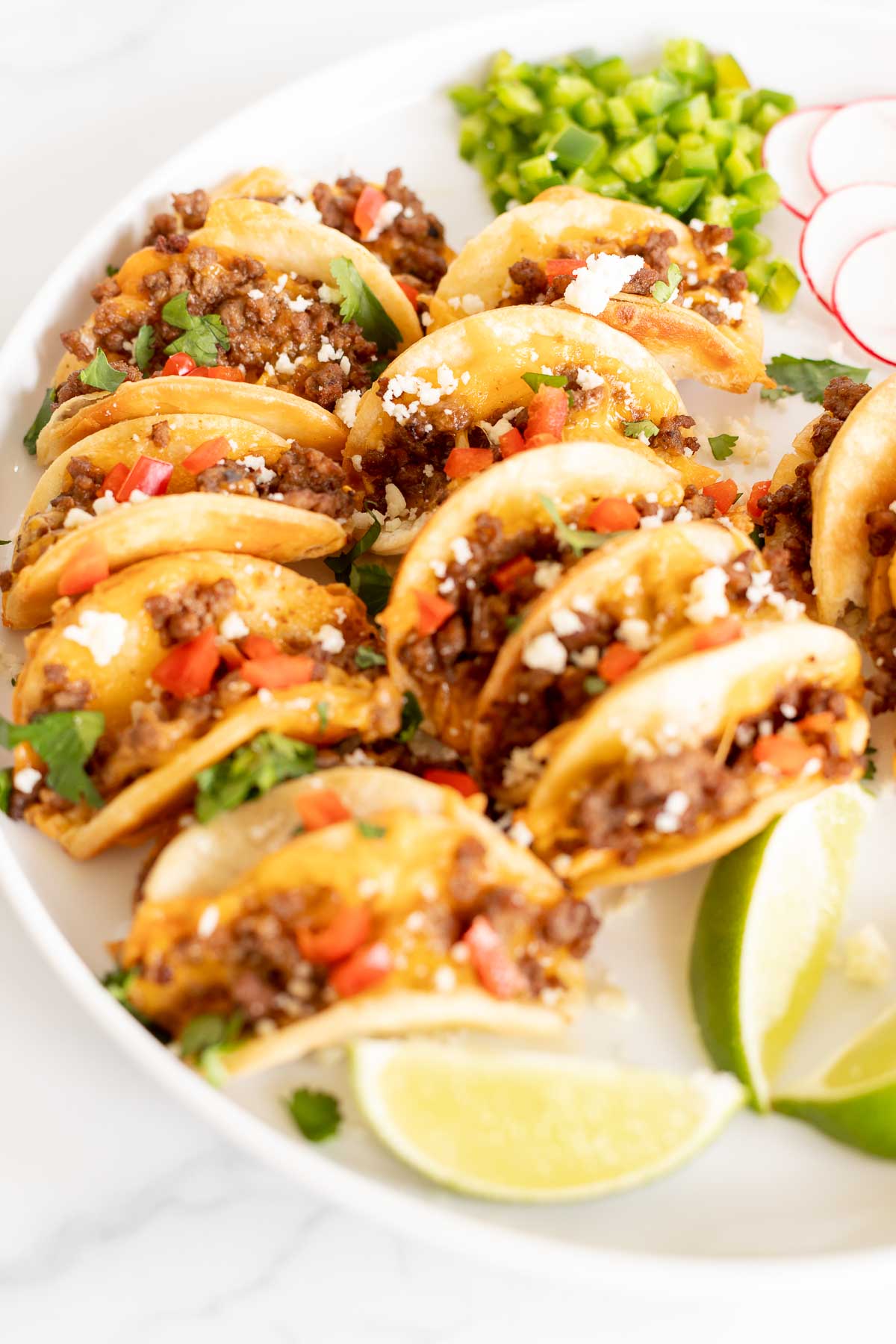 Beef mini tacos on a white platter.