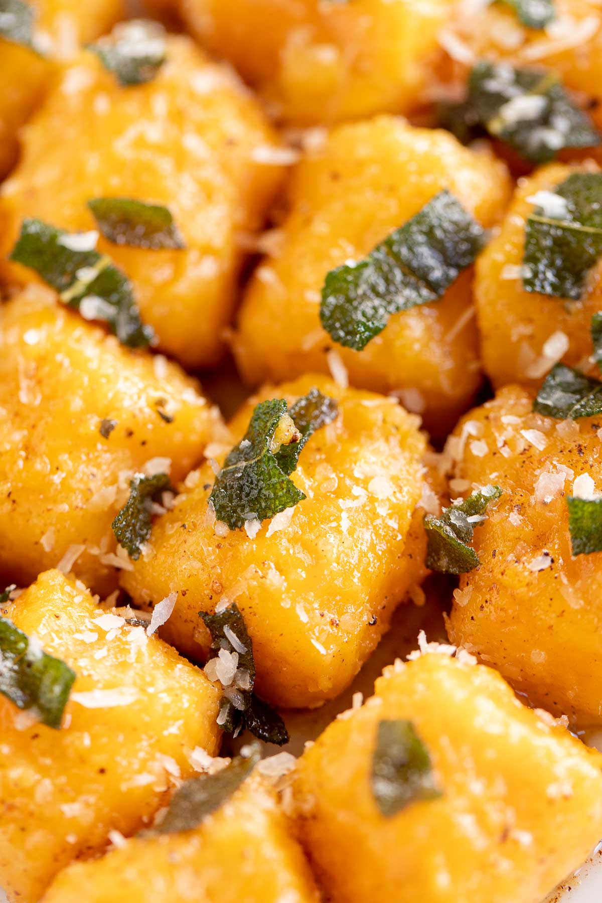 A delicious plate of sweet potato gnocchi topped with basil and parmesan cheese.