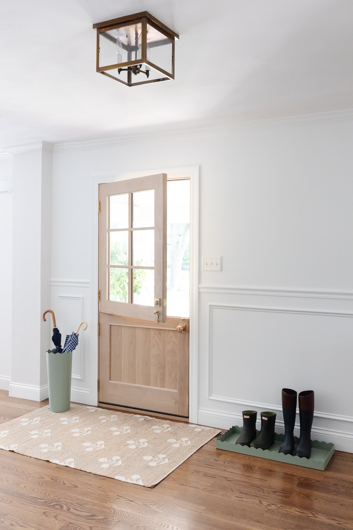 A doorway with a neutral rug and a light fixture.