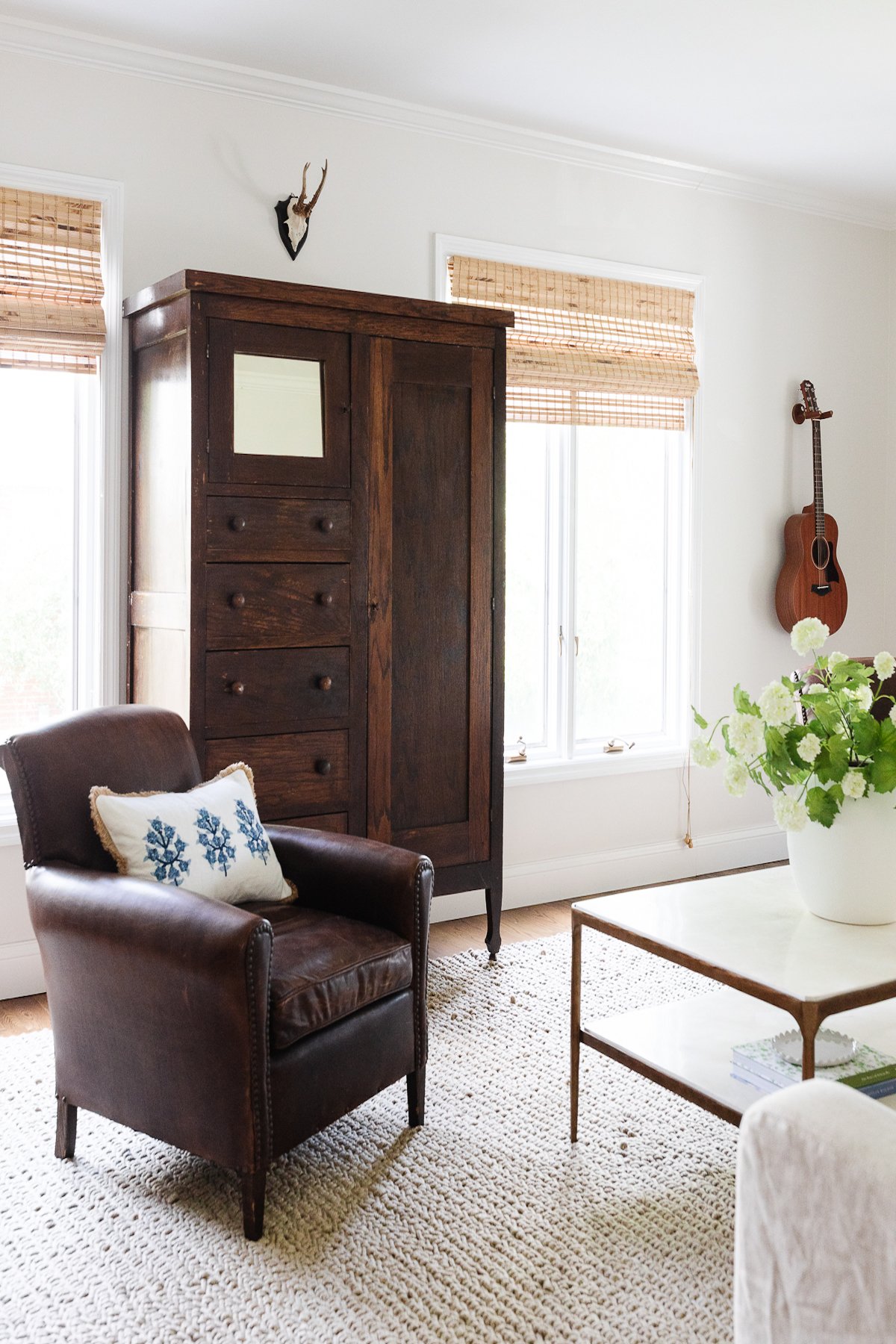 A chair in a living room with neutral rugs.