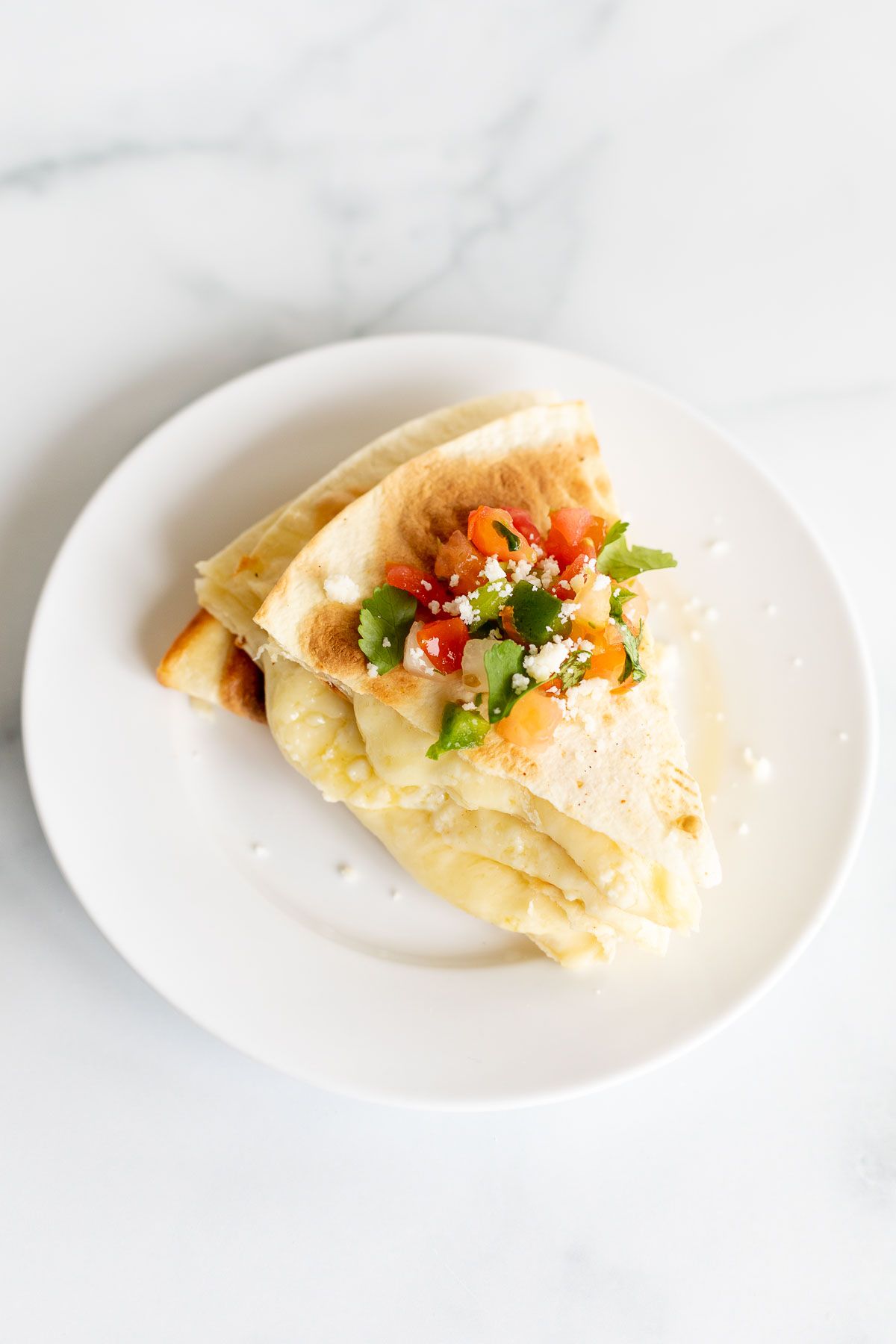 A stack of cheese quesadillas on a white plate