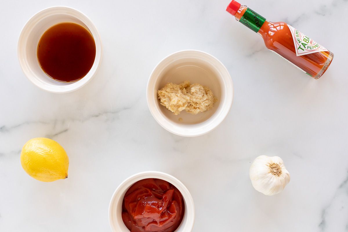 Ingredients for homemade cocktail sauce laid out on a marble counter top