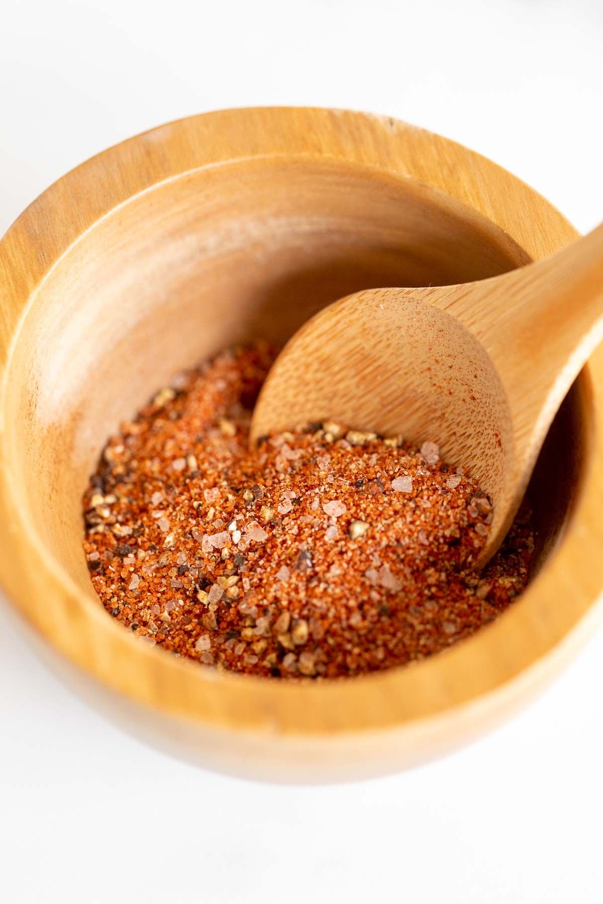 A small wooden bowl full of hamburger seasoning
