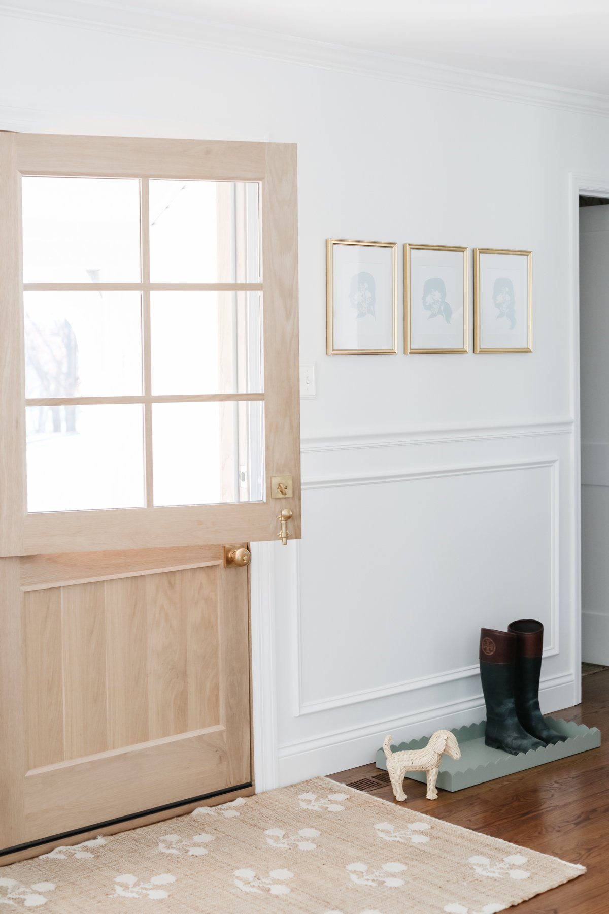 A neutral rug adorns the entryway alongside a wooden door.