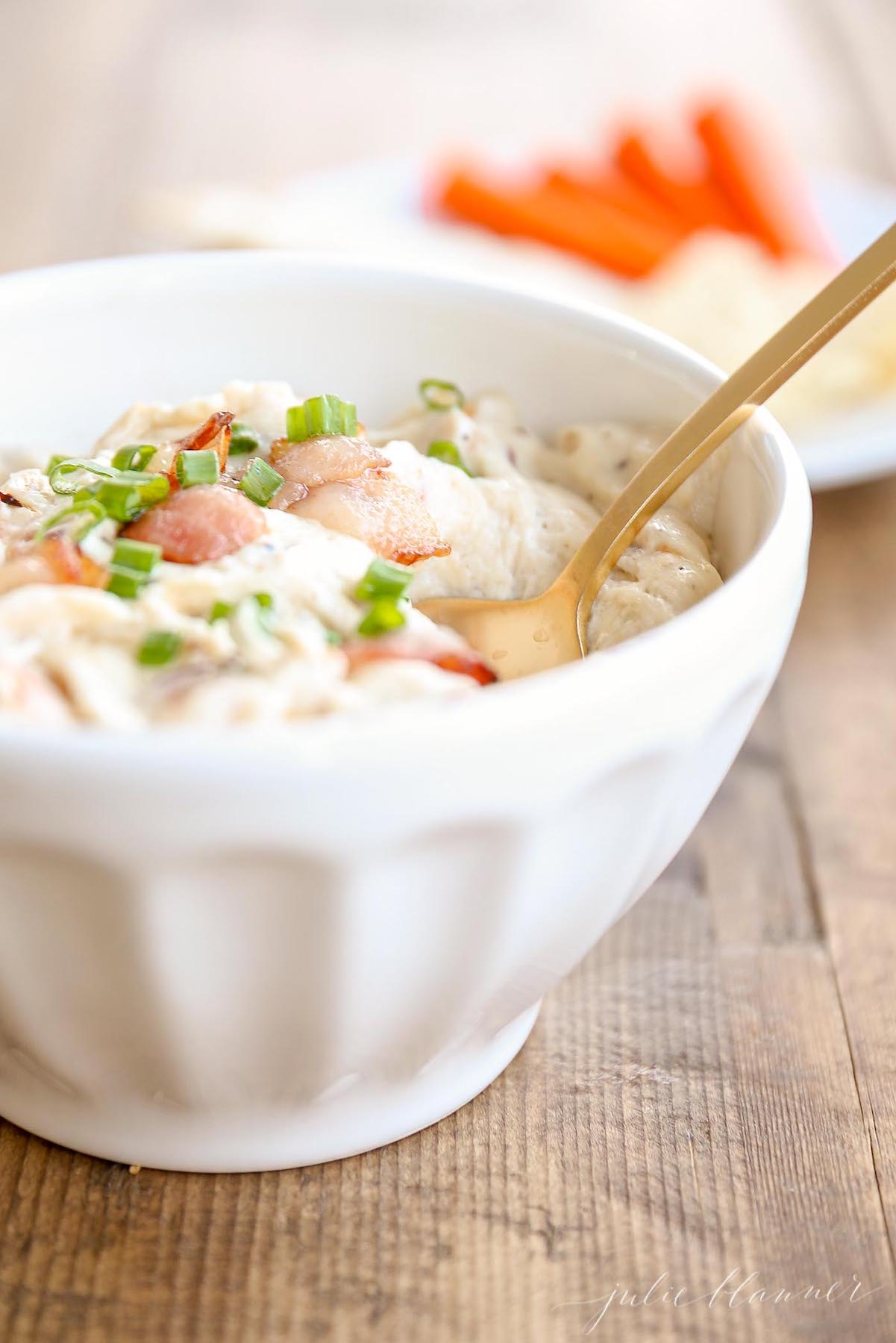 A white bowl full of bacon and cheese dip for a Thanksgiving appetizer