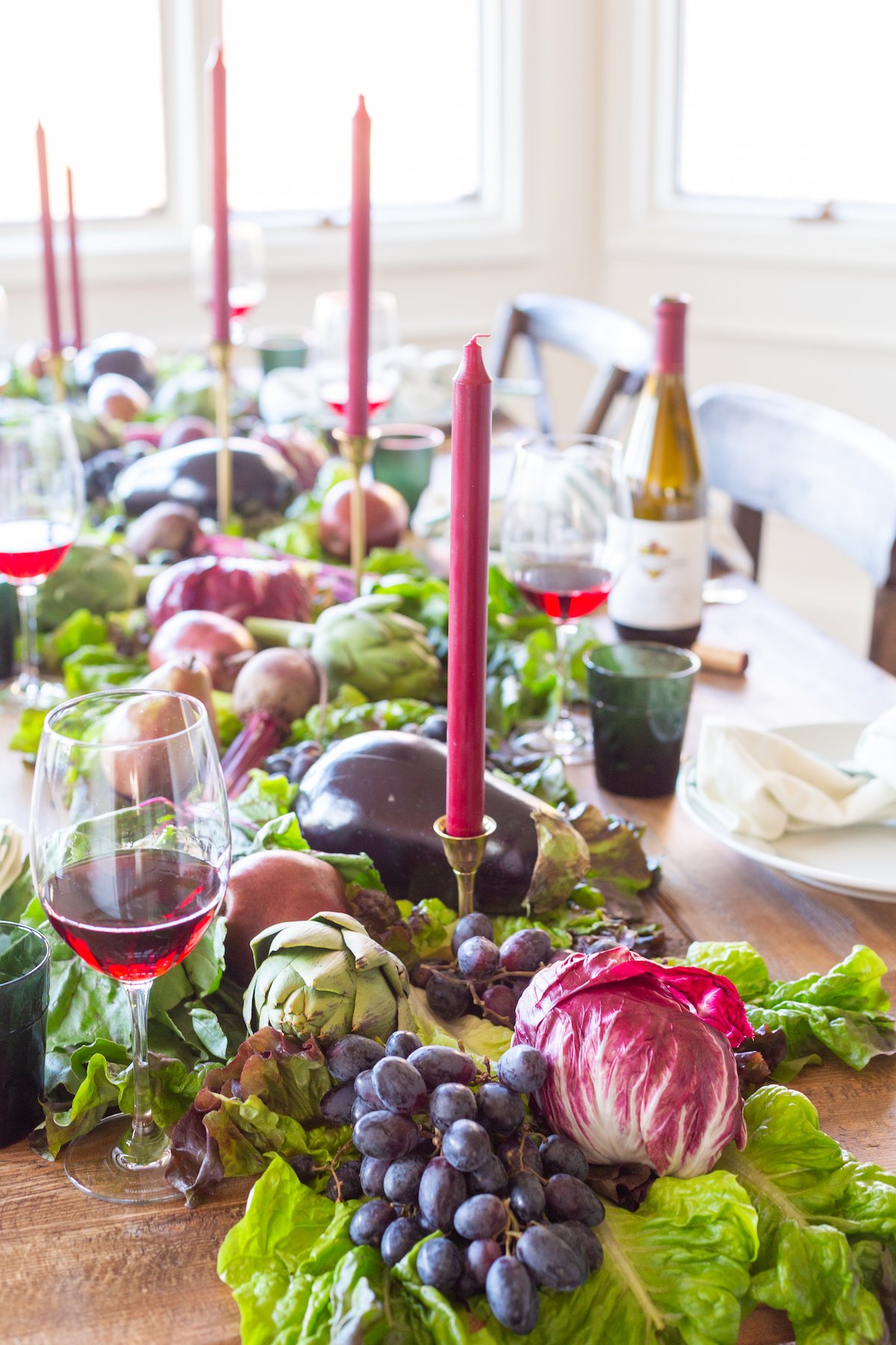 A Thanksgiving table with a lot of food on it, beautifully adorned with Thanksgiving centerpieces.