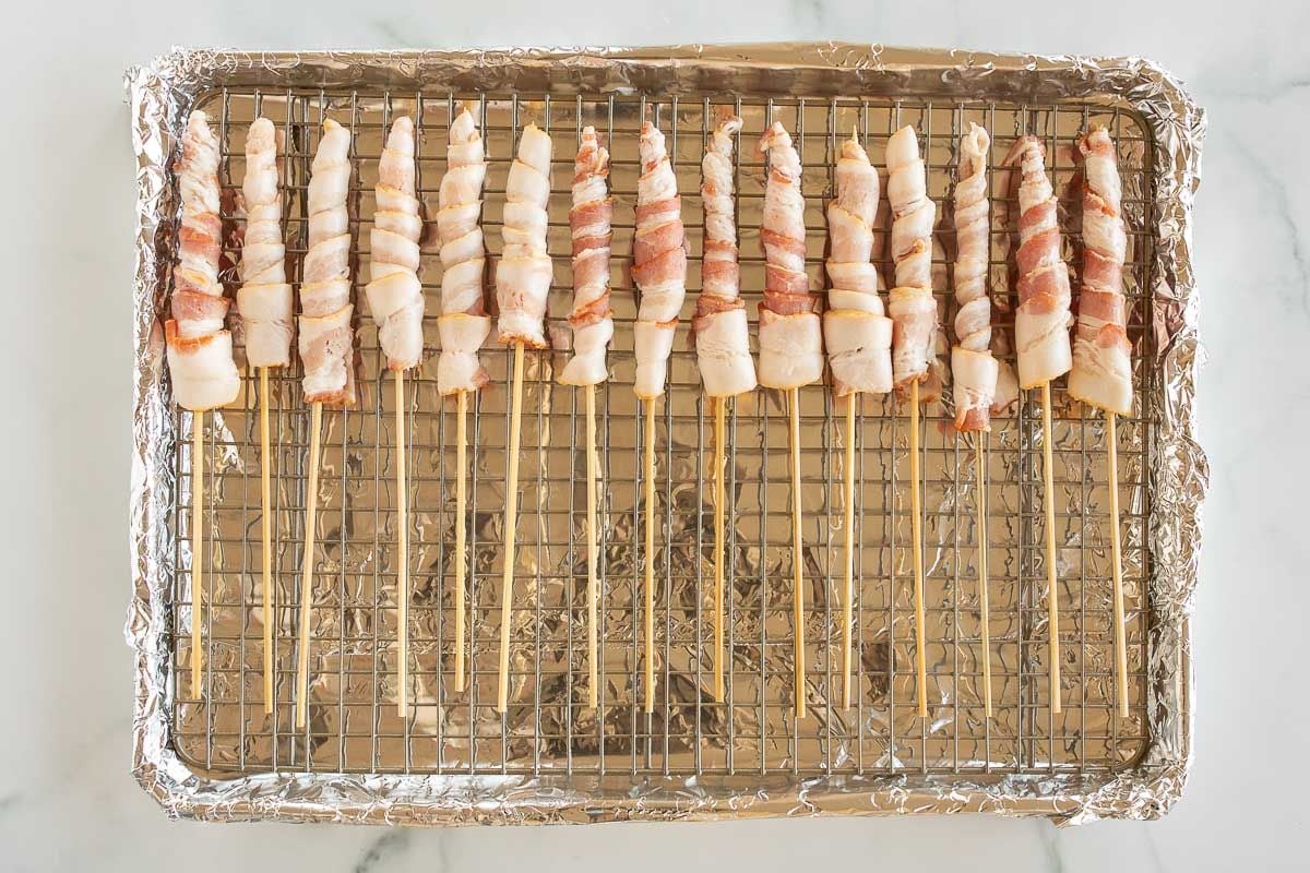 Caramel bacon on skewers, laid out on a baking sheet