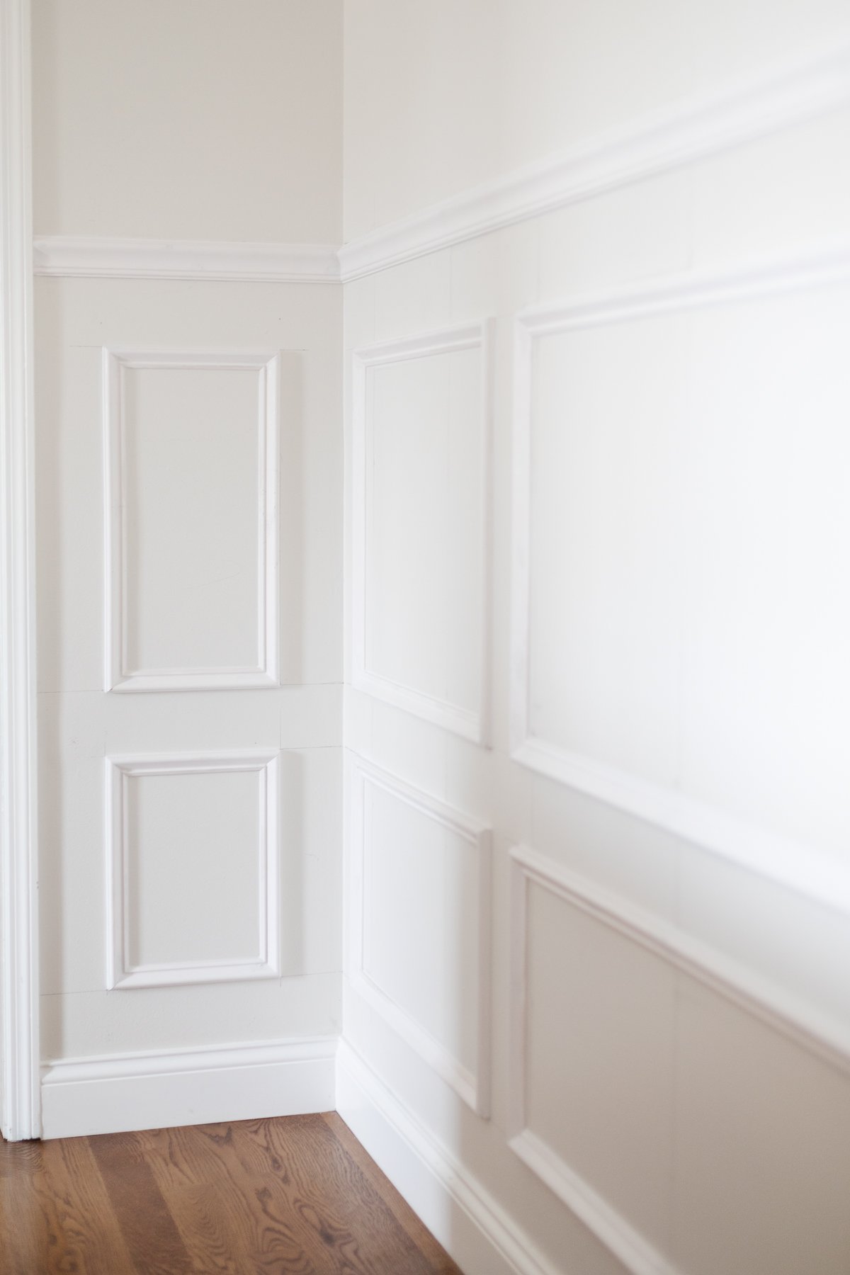 A dining room with window box molding, painted in Benjamin Moore Chantilly Lace.