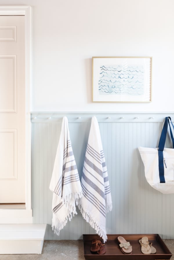 mudroom in garage with peg rail and shoe tray