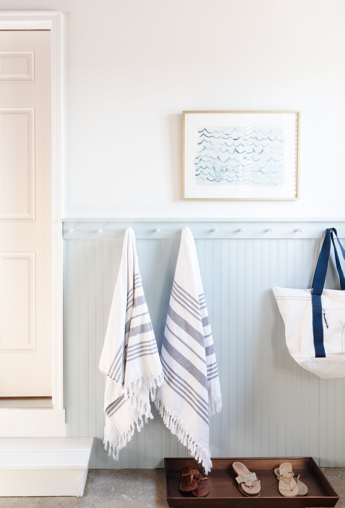 mudroom in garage with peg rail and shoe tray