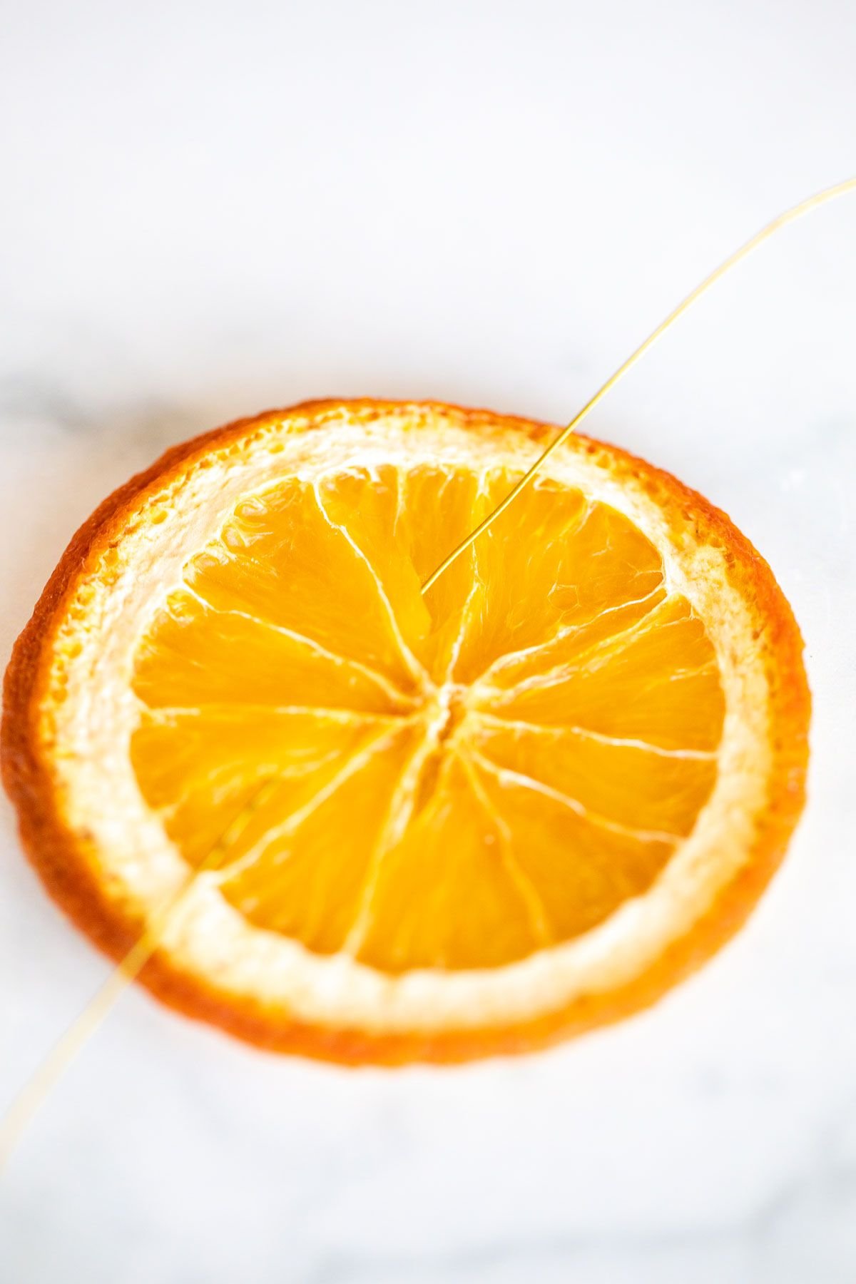 A dried orange slice on a marble surface