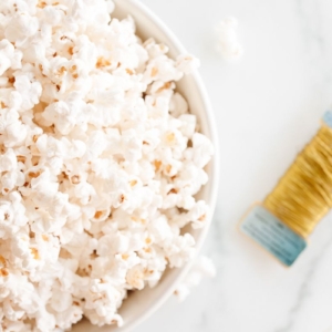 A bowl of popcorn next to a bolt of gold wire.