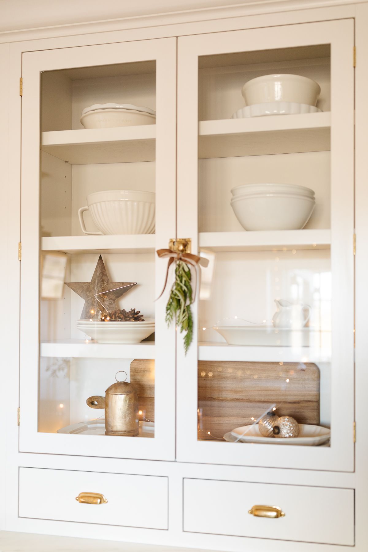 Traditional Christmas decorating, with gold stars and bells behind a glass cabinet