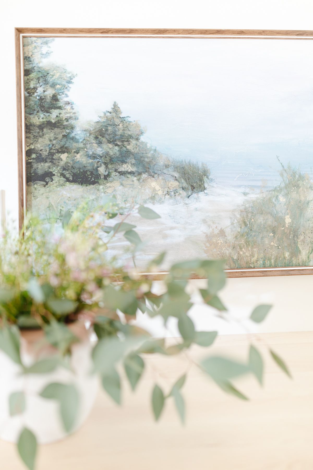 A close up of a framed piece of art over a butcher block countertop