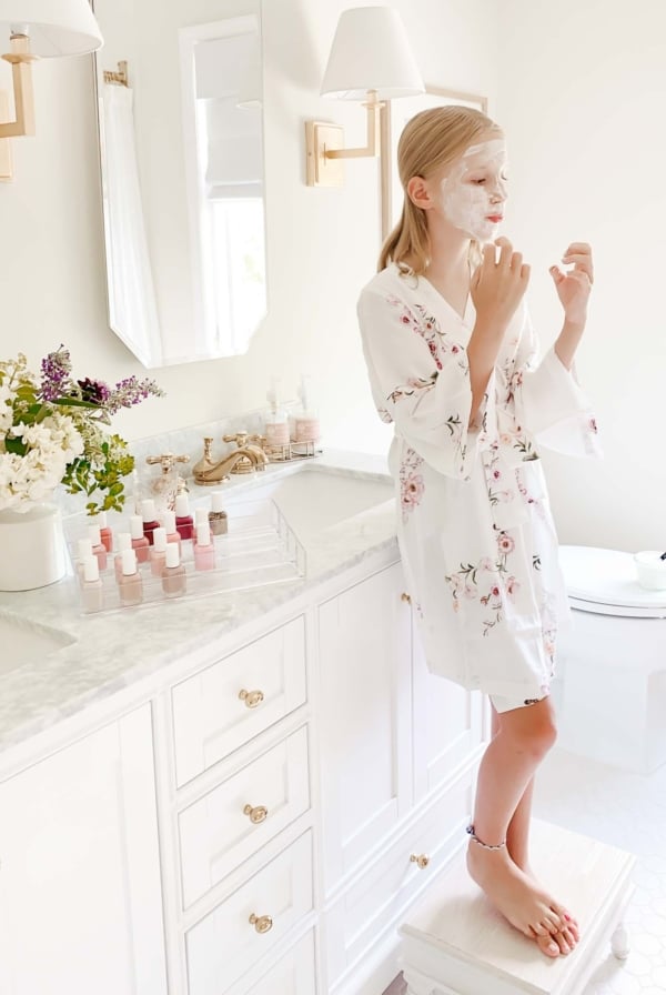 girl blowing on nails in organized bathroom