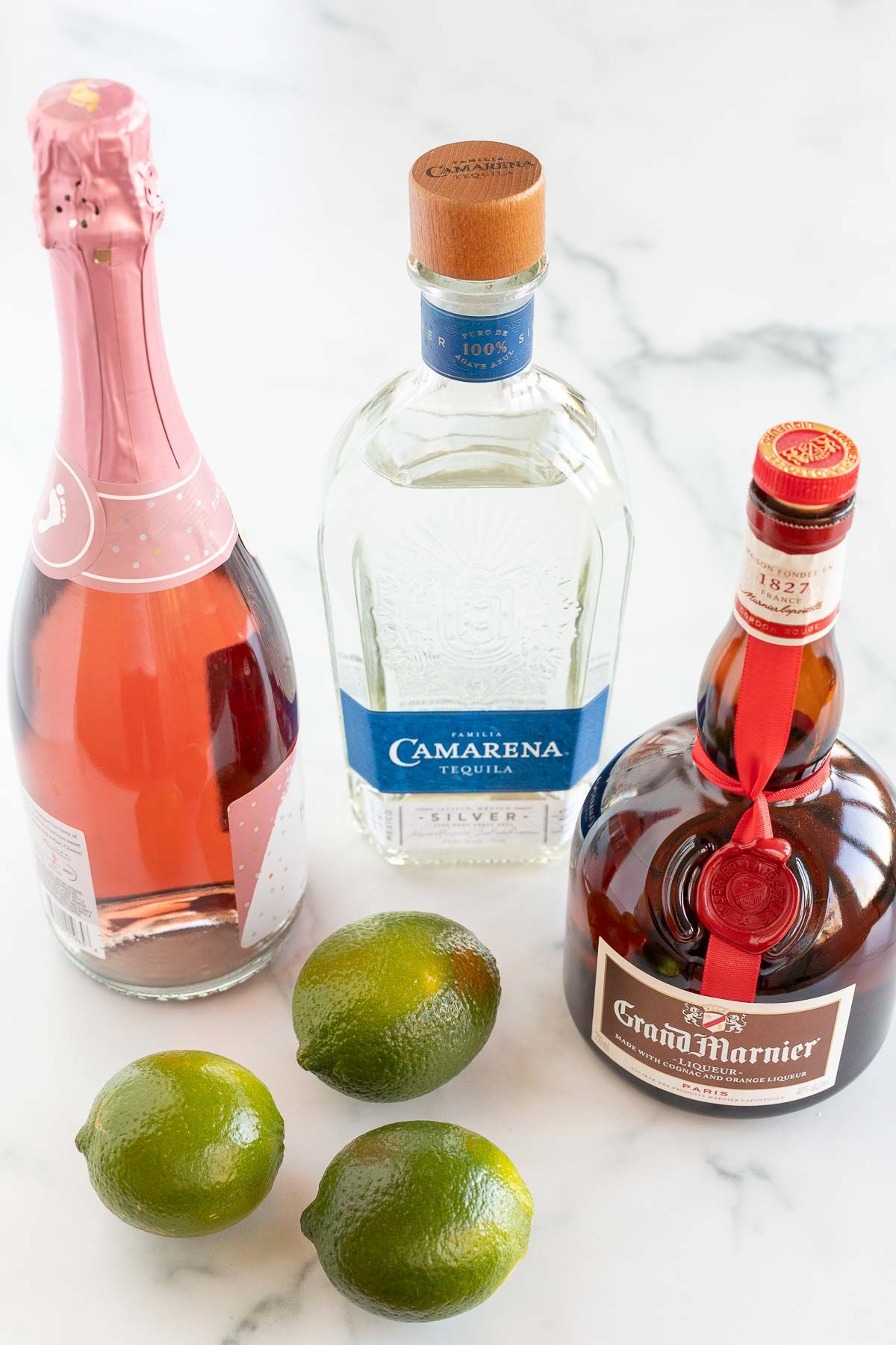 Ingredients for a champagne margarita laid out on a marble surface