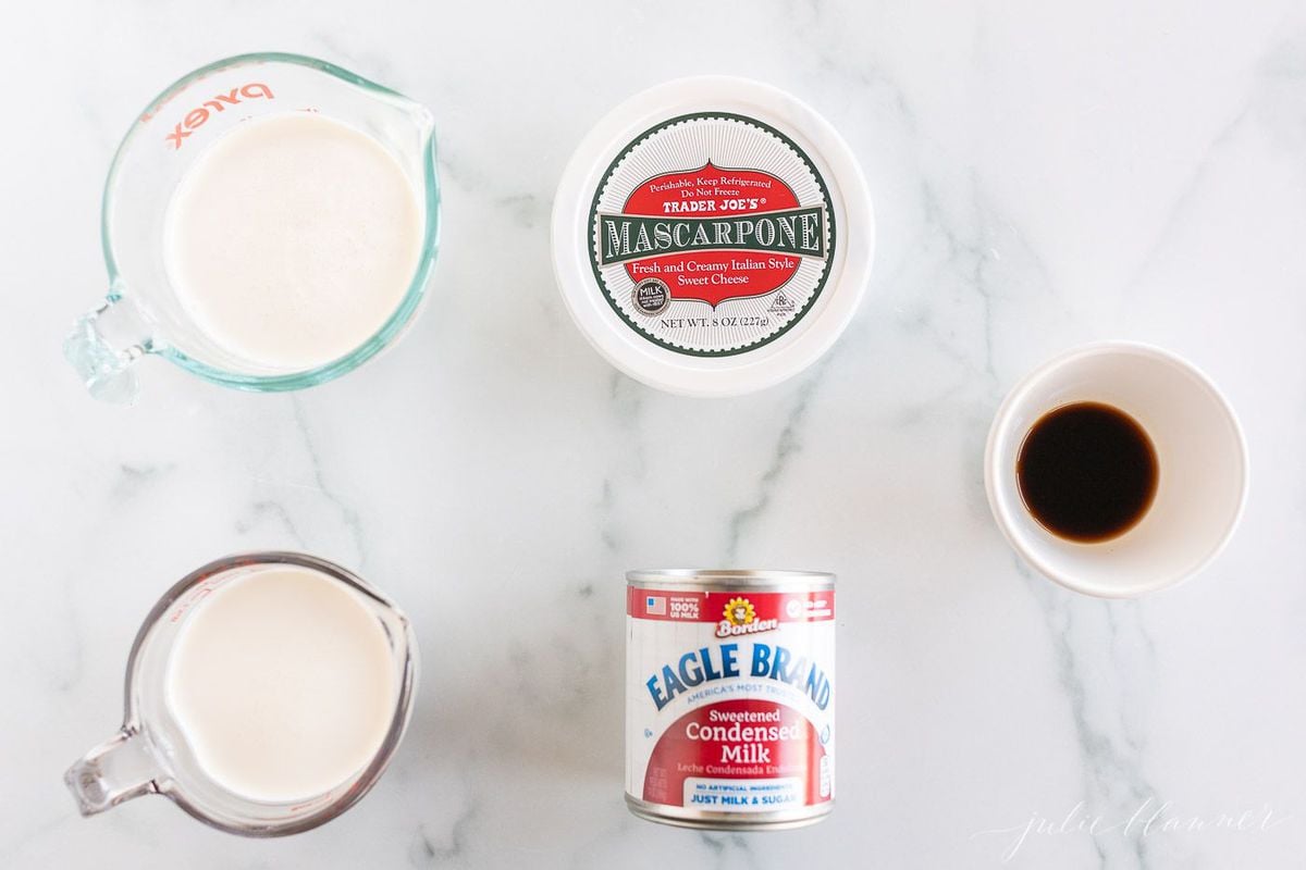 Ingredients for a homemade mascarpone ice cream recipe laid out on a marble surface