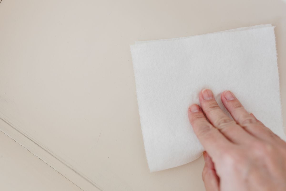 Wiping an empty nightstand drawer out for organization