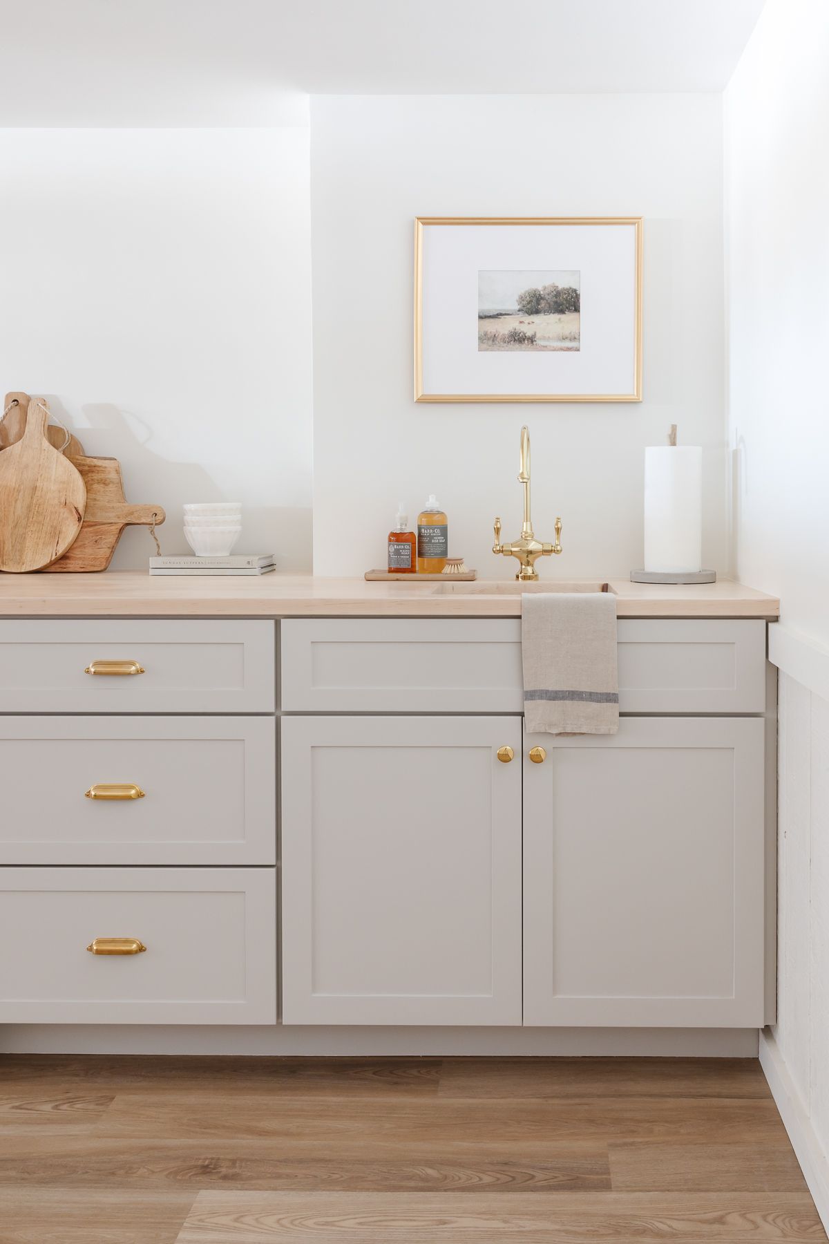 A basement bar with gray cabinets and butcher block countertops