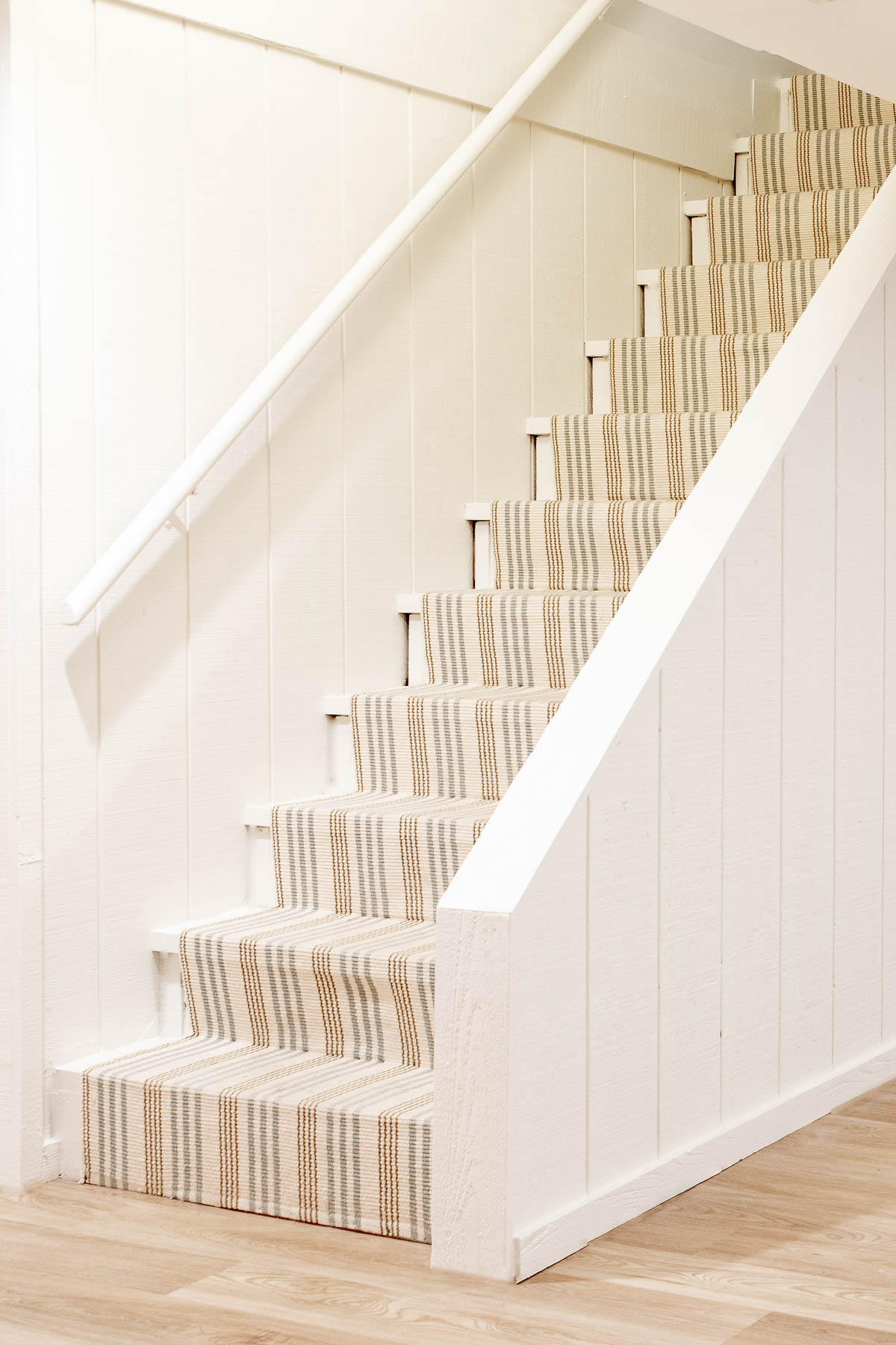 A diy stair runner in a blue and neutral stripe.