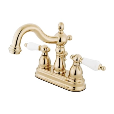 A brass bathroom faucet with white handles.