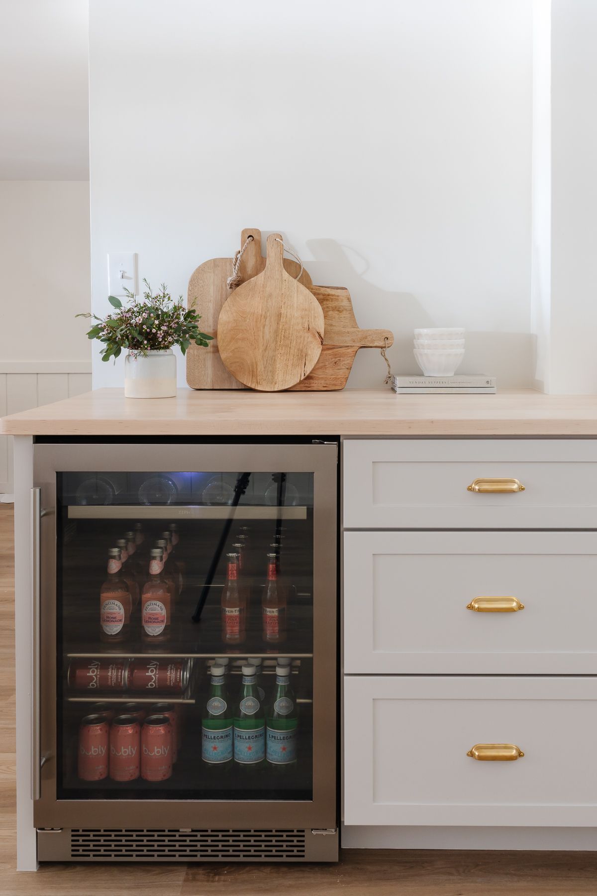 Wood countertops on a basement bar over a beverage refrigerator