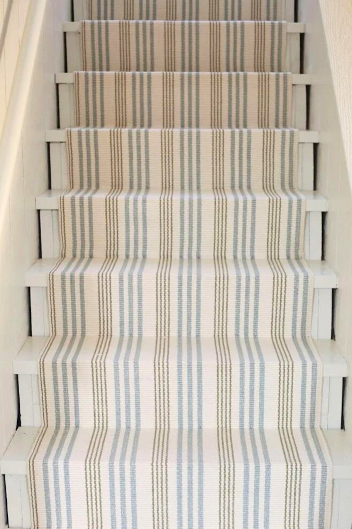 A diy stair runner in a blue and neutral stripe.