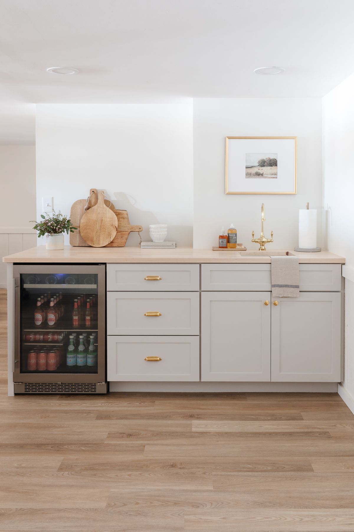 A basement bar with the cabinetry painted Sherwin Williams Agreeable Gray and walls in Swiss Coffee