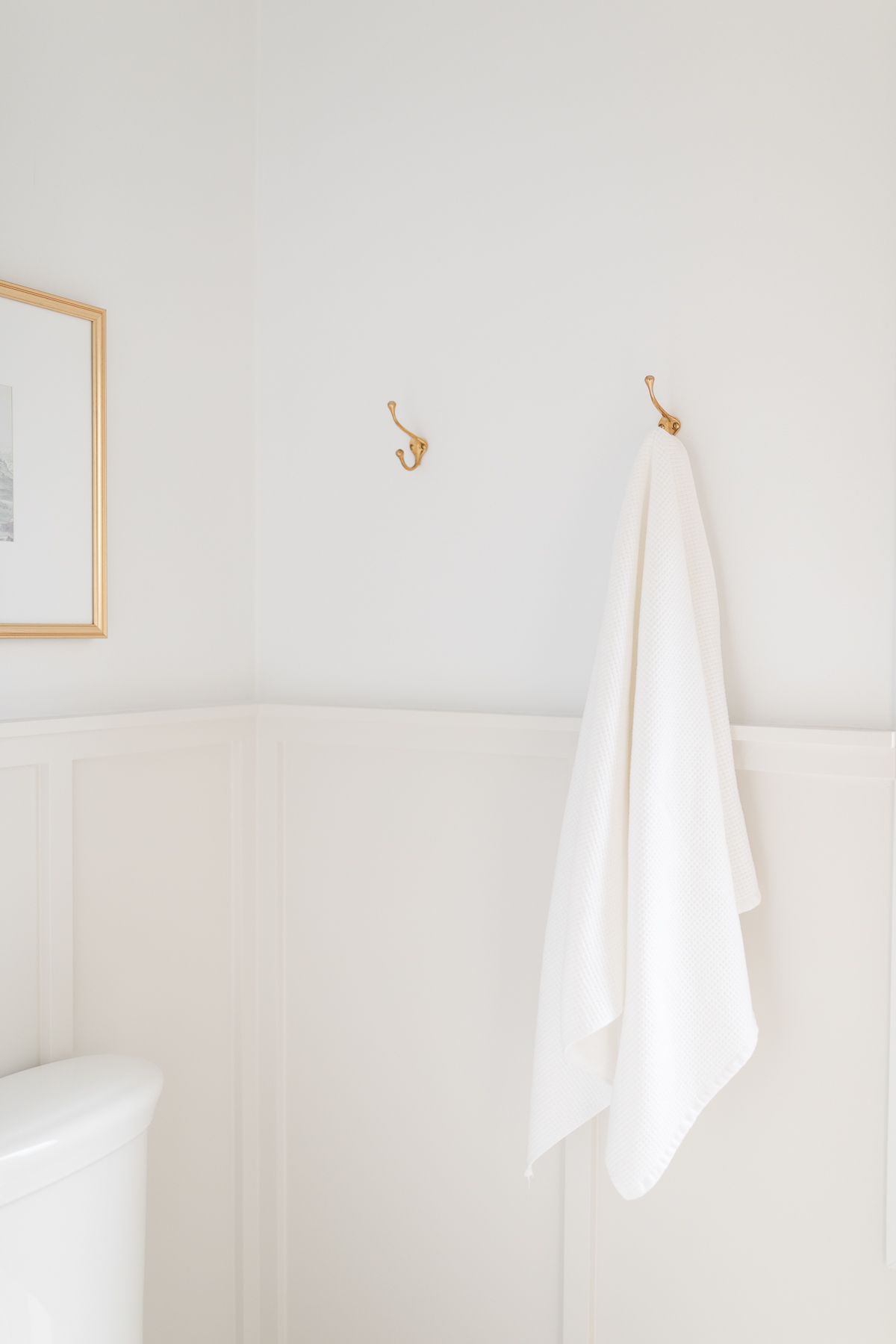 A bathroom with light gray board and batten wall paneling