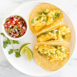 Three breakfast tacos on a white plate