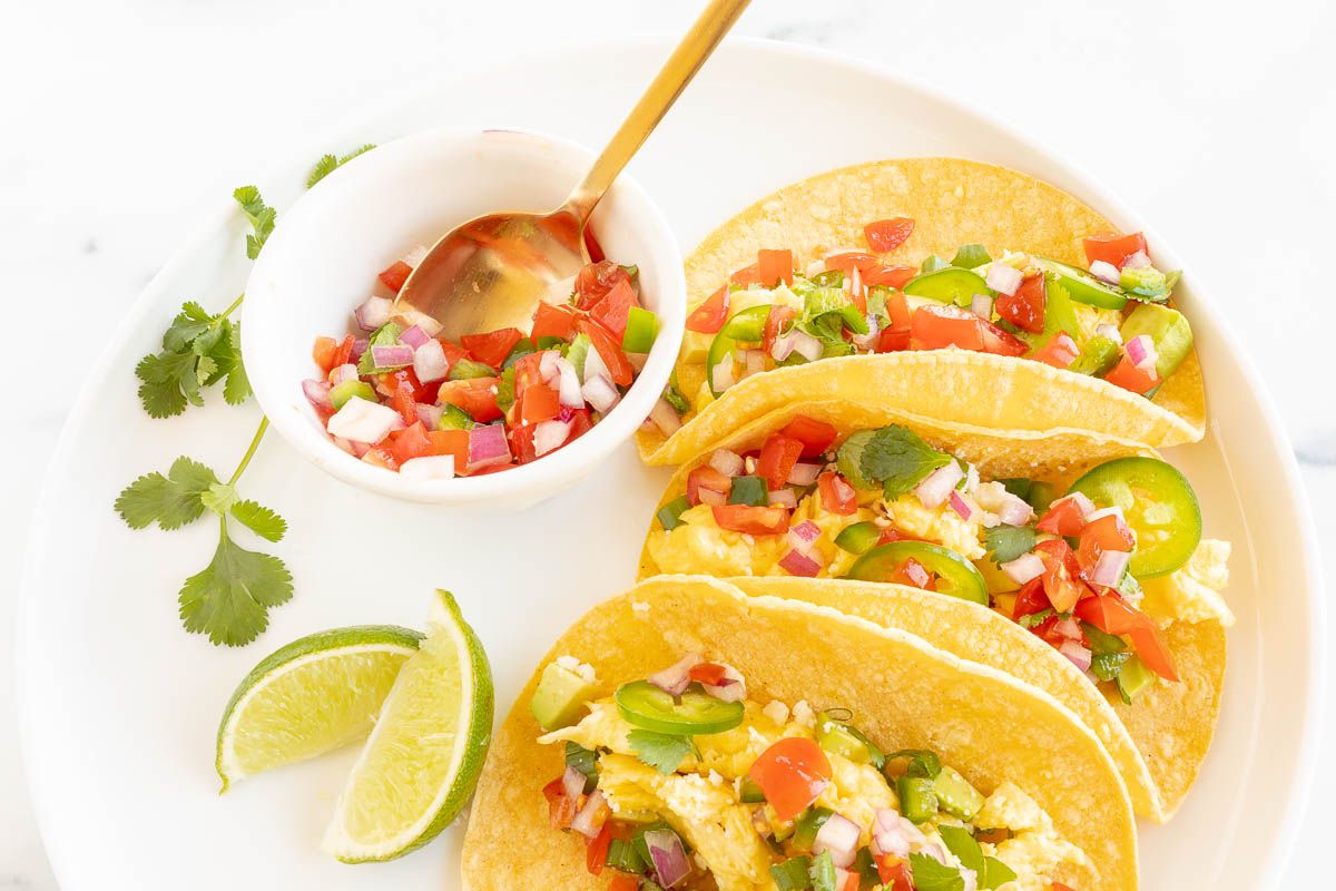 Three breakfast tacos on a white plate