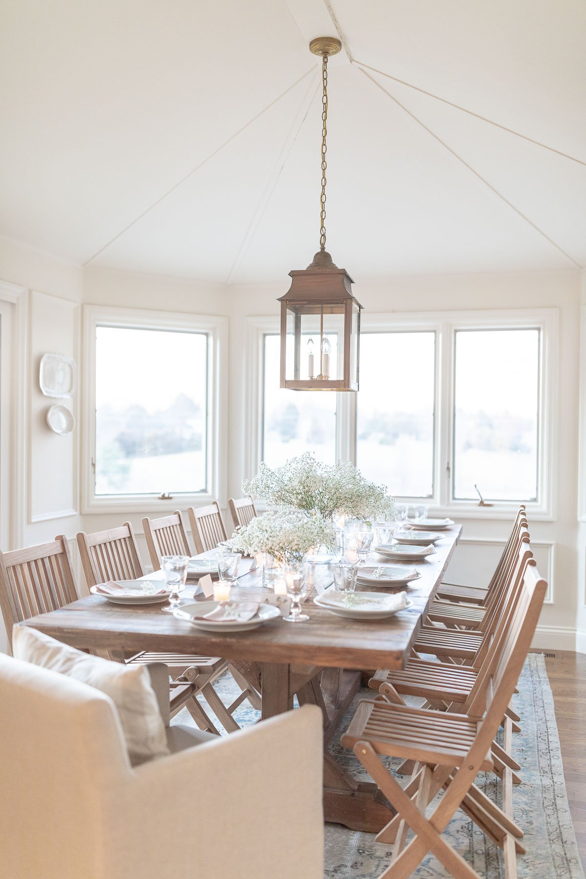 A dining room with a wood table, walls are painted in a cream paint color.