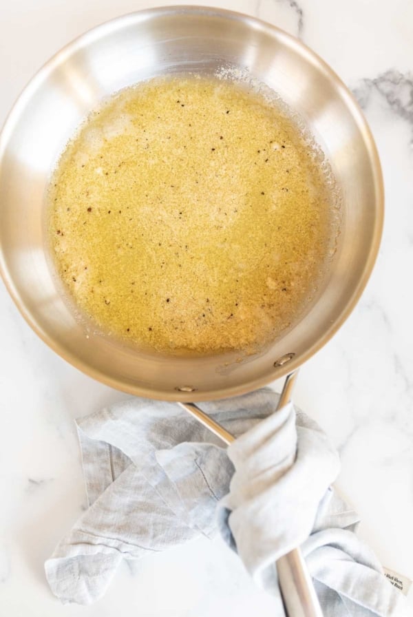 A silver sauce pan full of garlic parmesan sauce