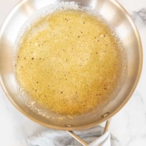 A silver sauce pan full of garlic parmesan sauce