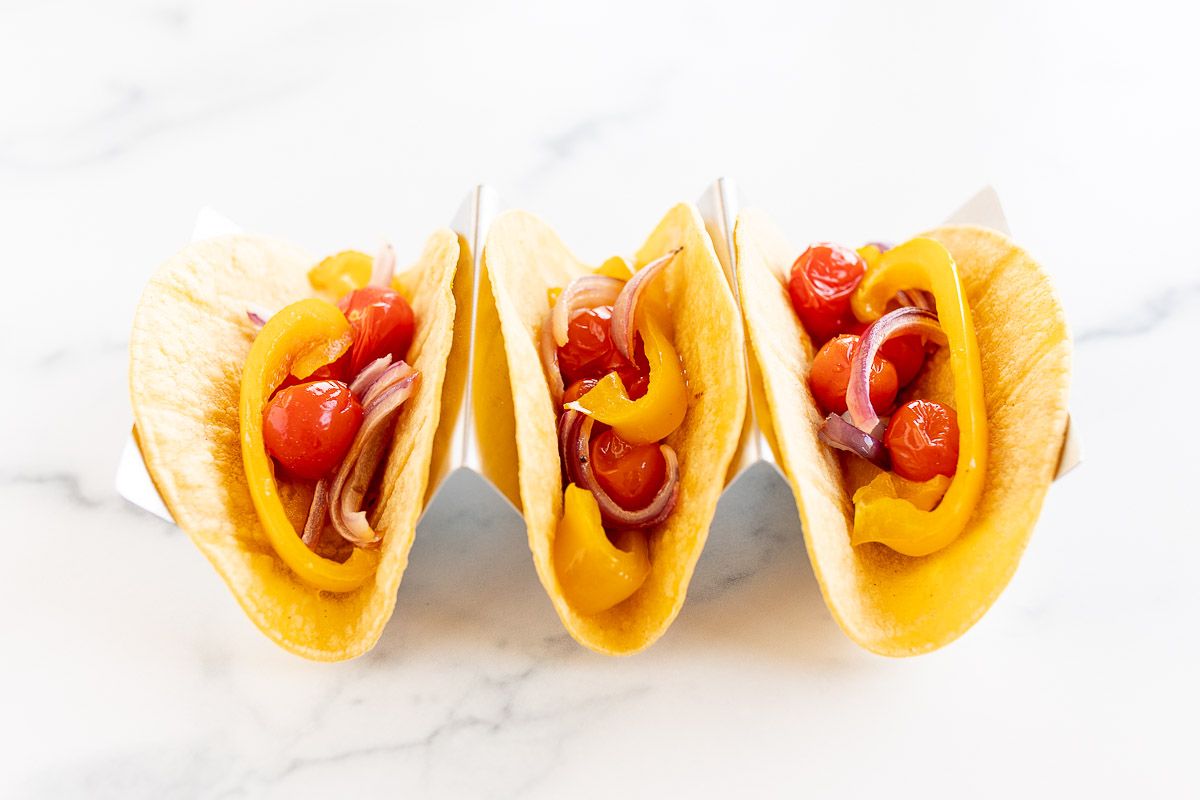 A plate of vegetarian tacos in corn tortillas